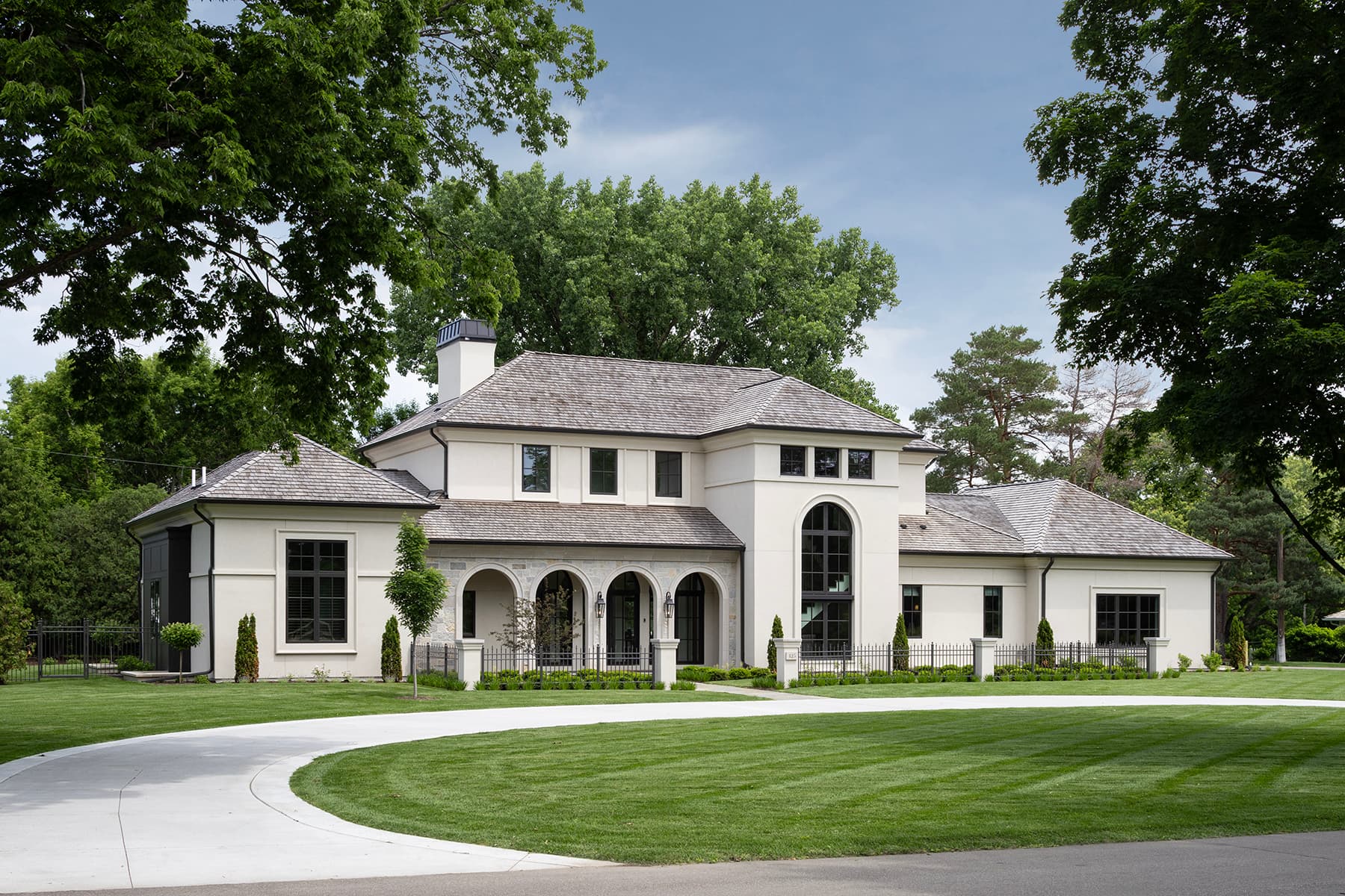 Highcroft lakeside exterior framed by mature trees and curved drive