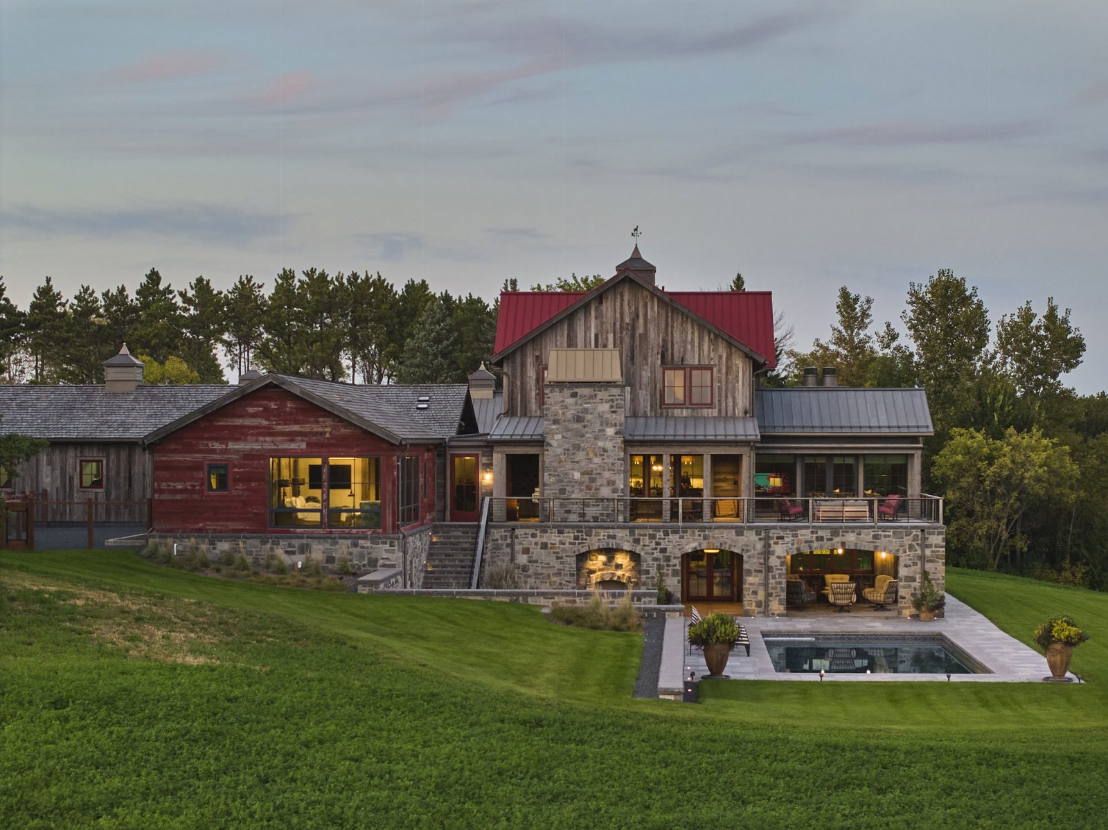 Timber Retreat rear elevation at dusk with pool and red barn board wing