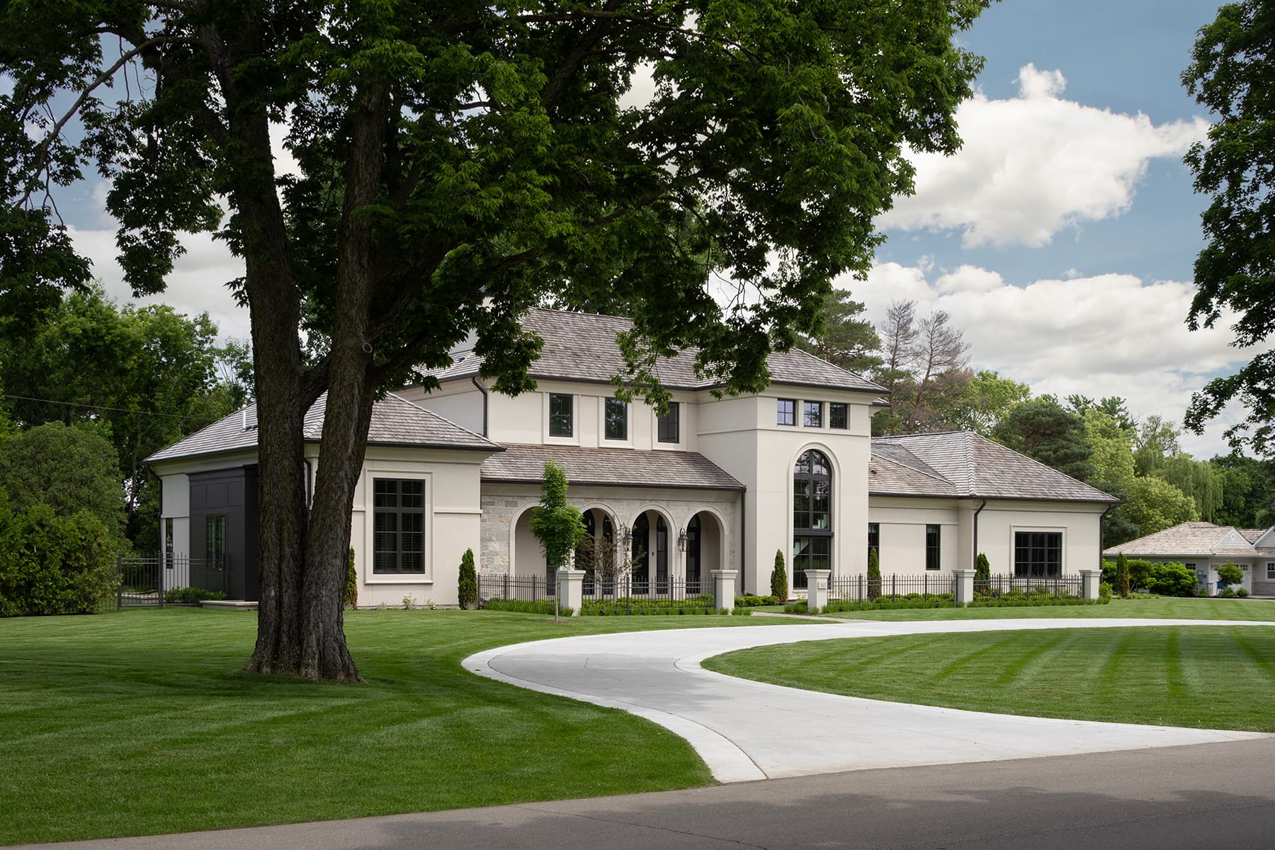 Highcroft classical stucco exterior with arched entry and limestone detailing