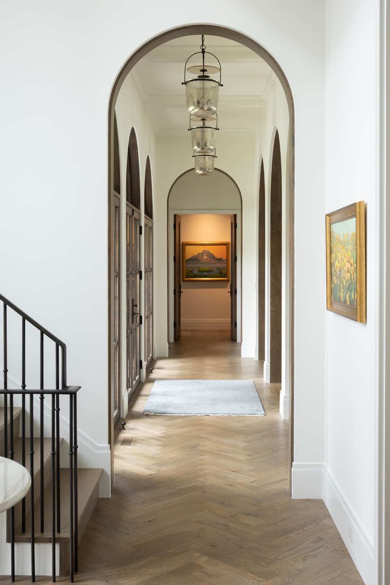 Highcroft arched gallery hall with herringbone oak floors and glass lanterns