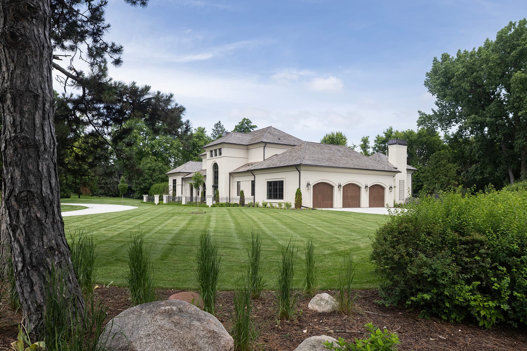 Highcroft side elevation across the striped lawn and native plantings