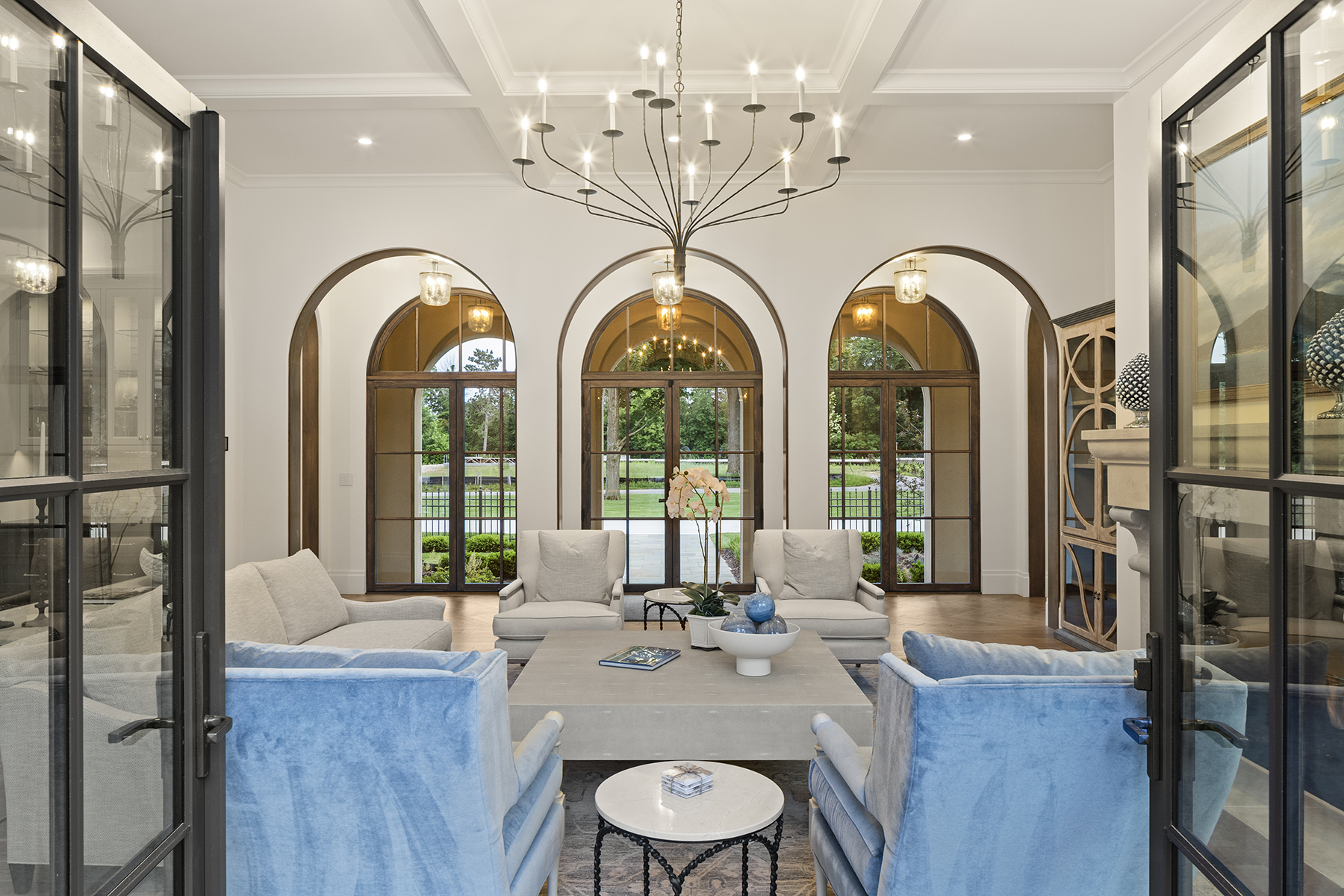 Highcroft living room seen through steel doors, arches aligned to the garden