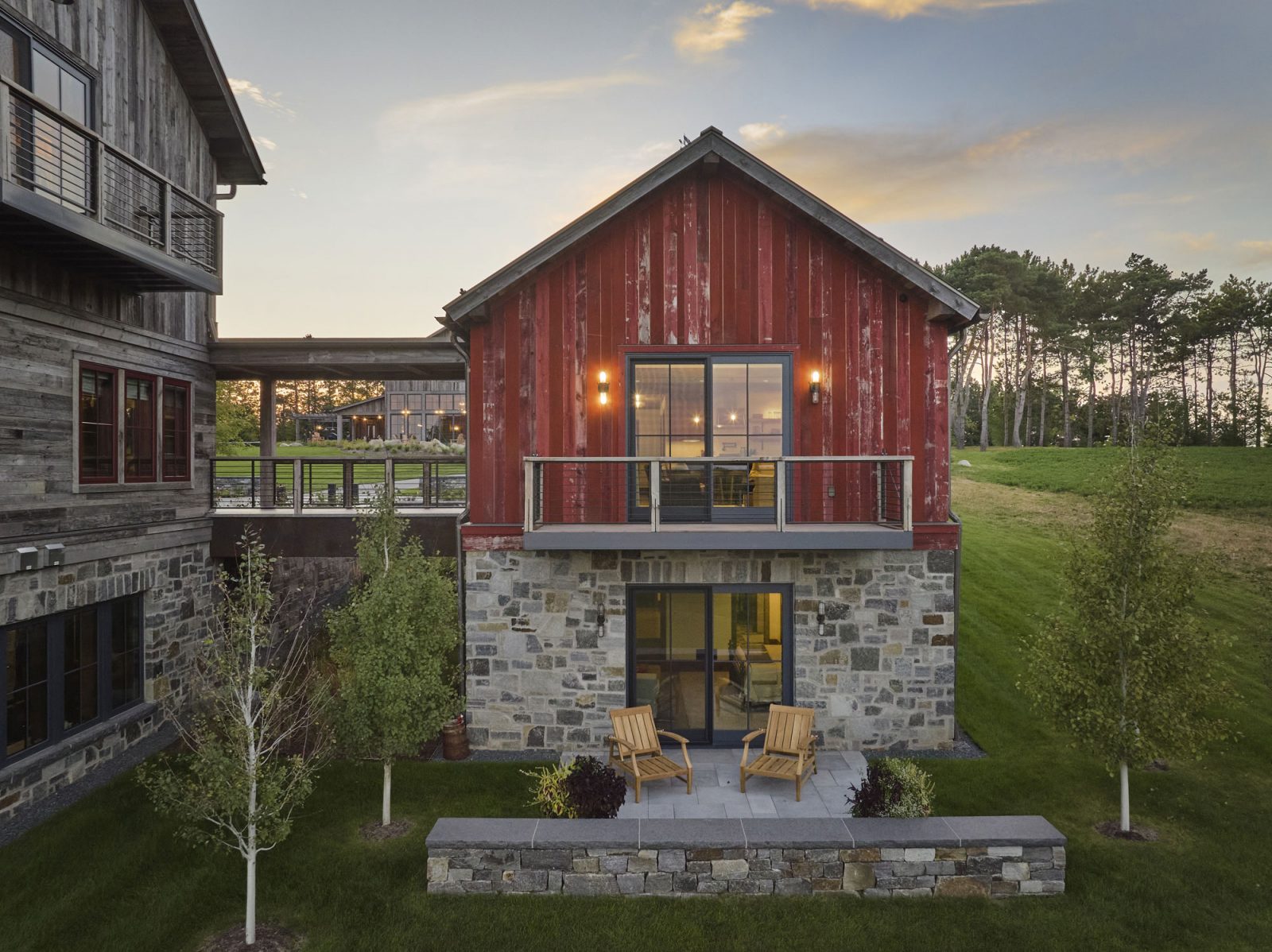 Timber Retreat red barn board guest wing with stone base and patio chairs