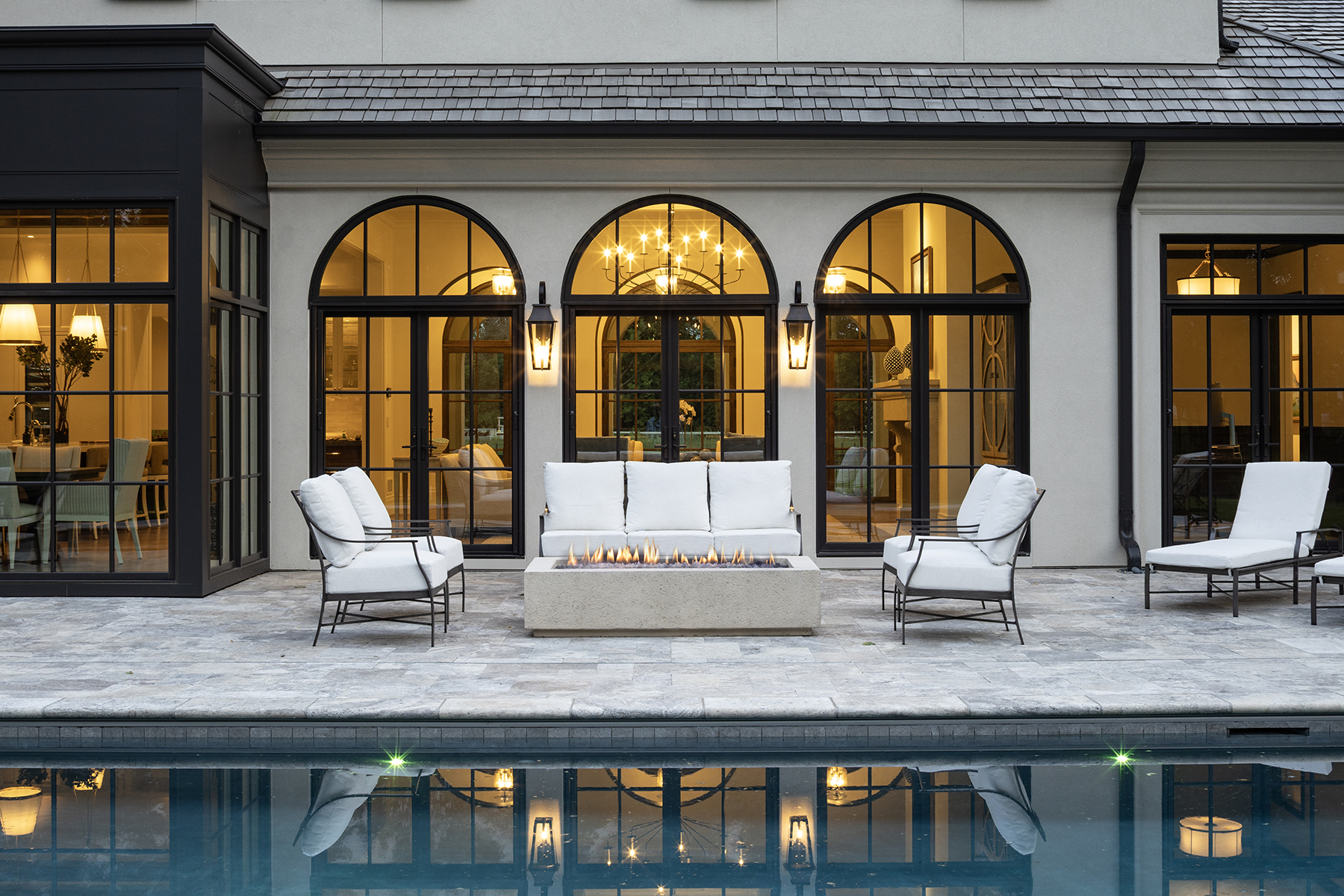 Highcroft arched loggia glowing over the pool at twilight