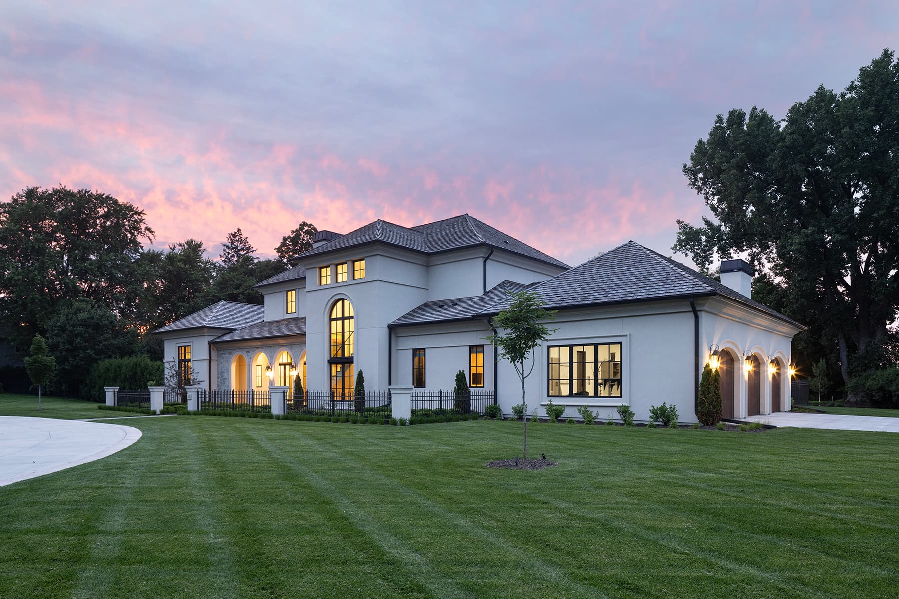 Highcroft front and side elevations beneath a dramatic pink sunset