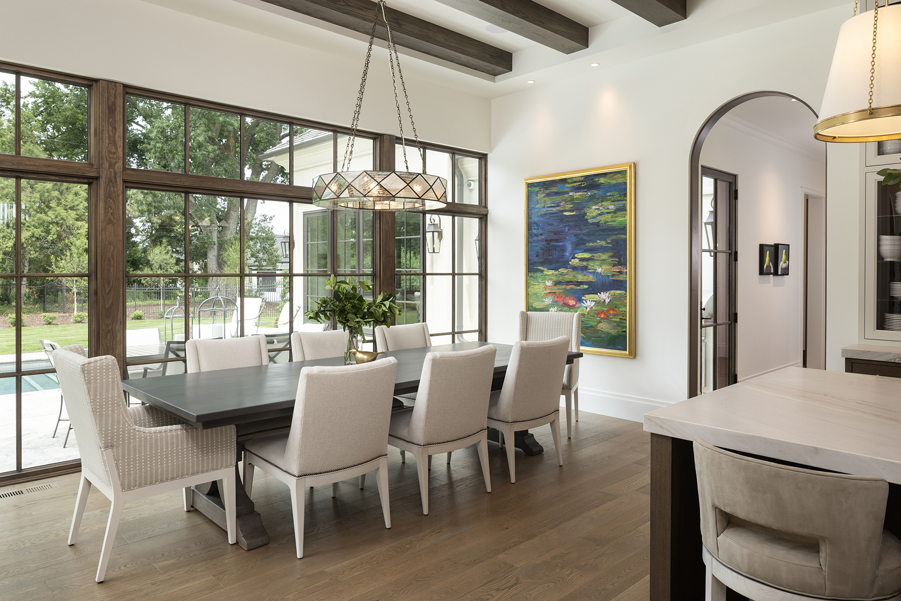 Highcroft dining room with beamed ceiling and walls of steel windows to the pool