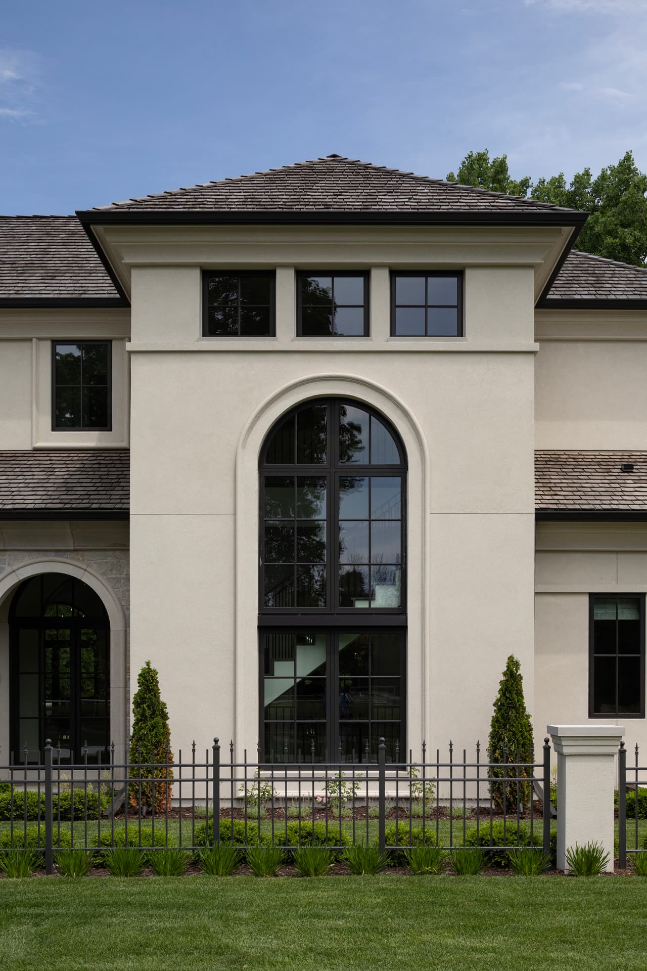 Highcroft arched stair window set in limestone-trimmed stucco