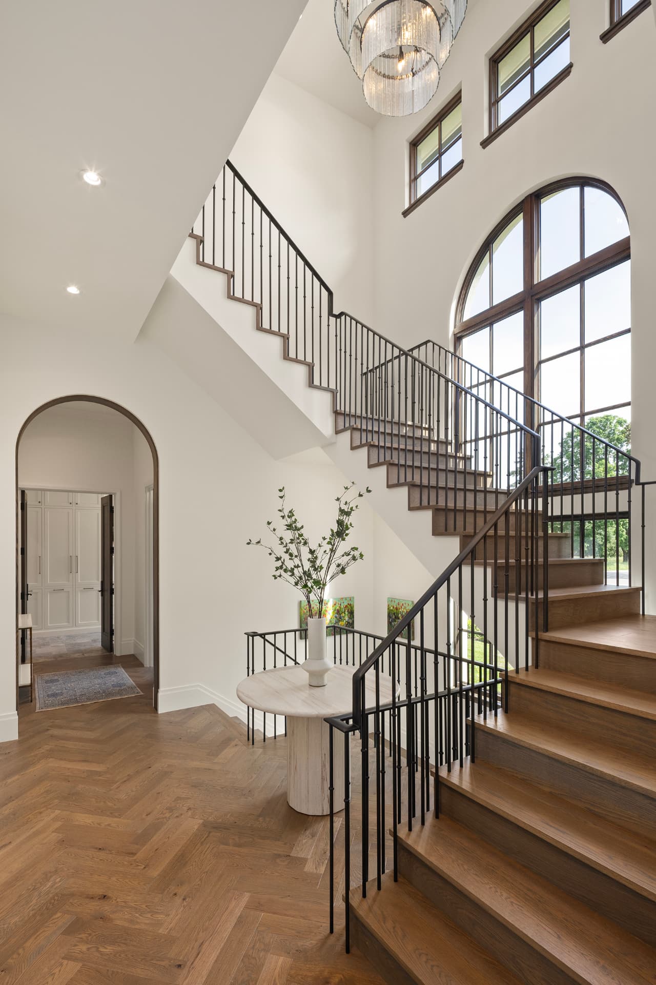 Highcroft entry stair hall with glass chandelier and arched window