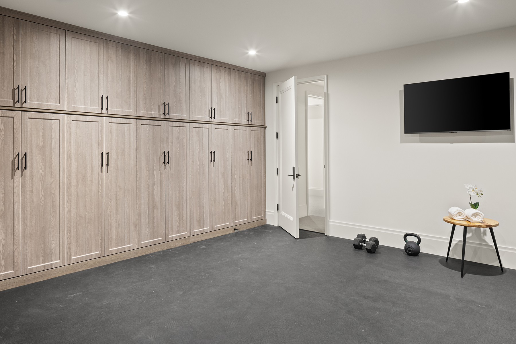 Highcroft gym with full wall of oak cabinetry and rubber flooring