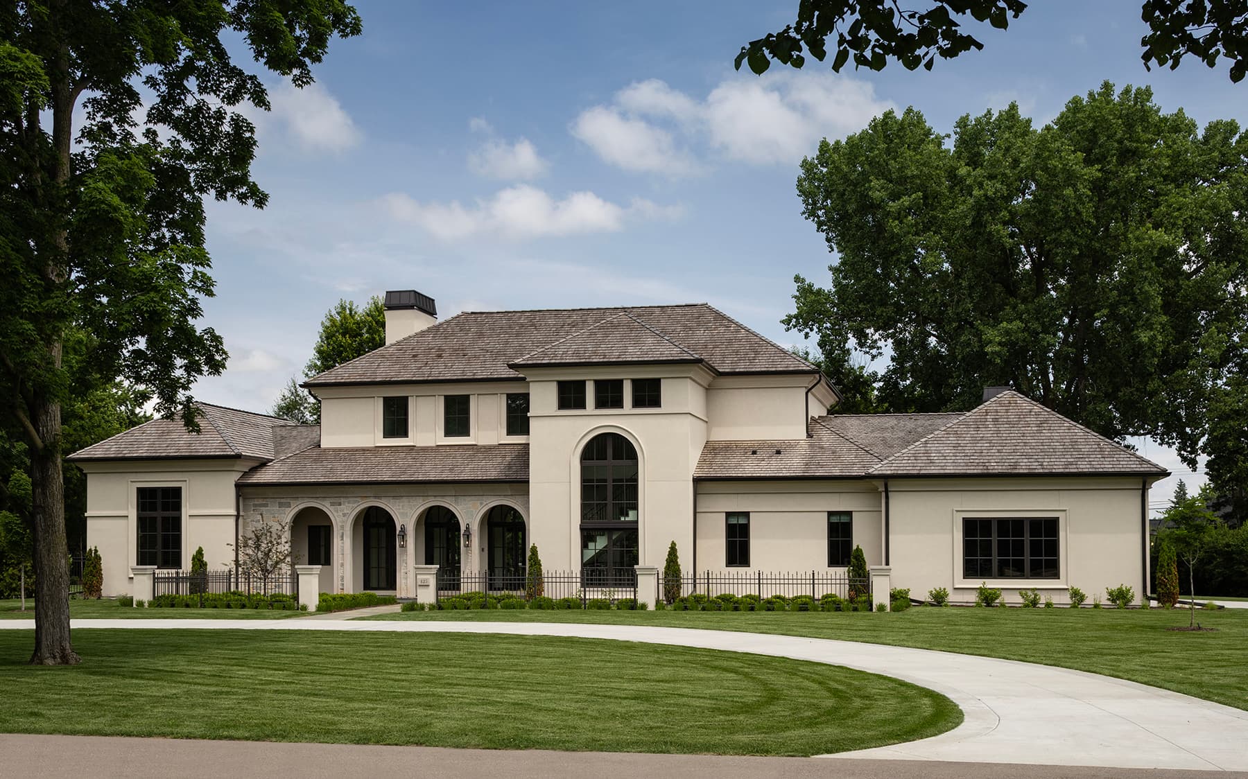 Highcroft front facade with tree-lined drive and arched windows