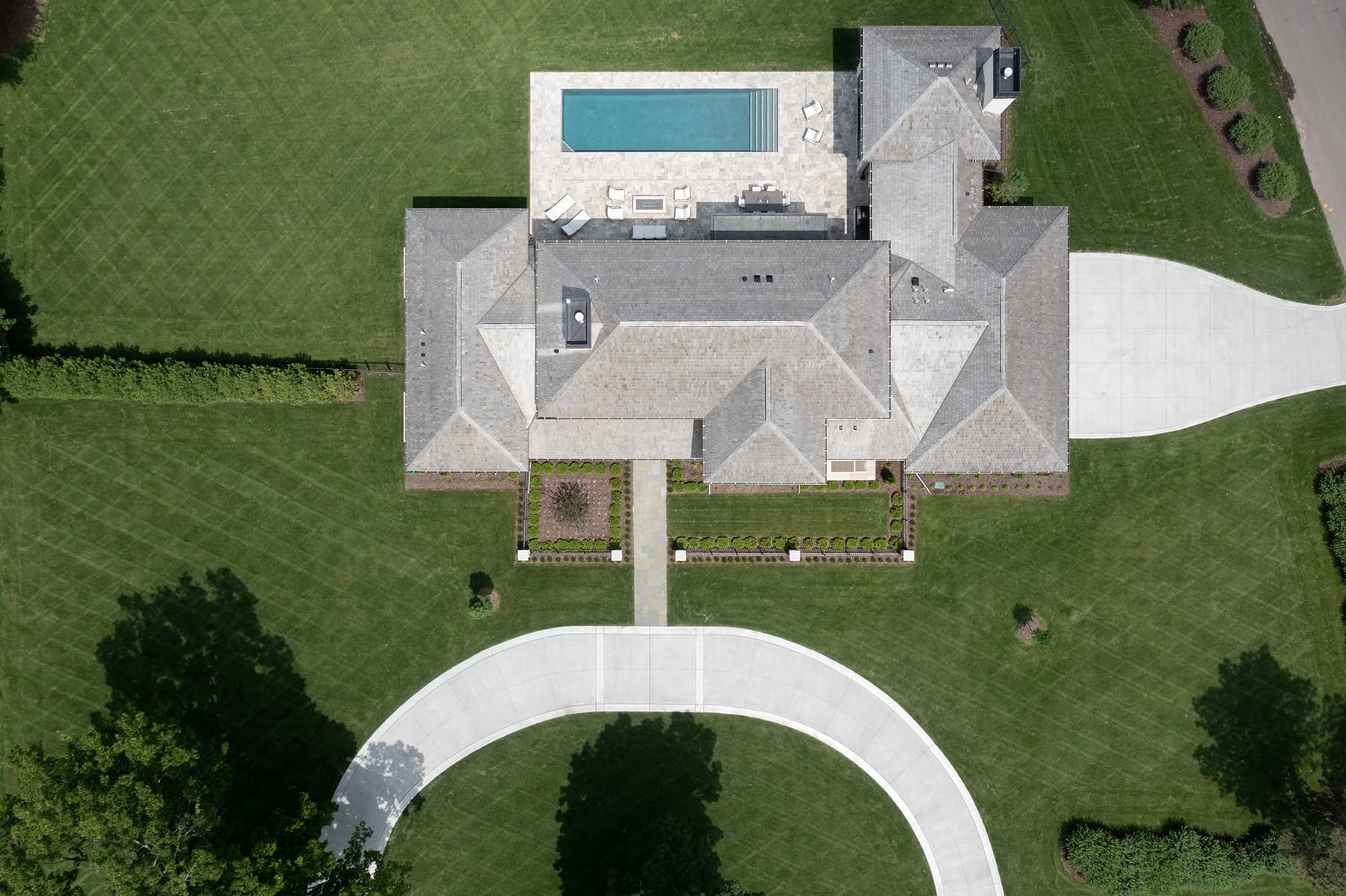 Overhead aerial of Highcroft's roofline, pool terrace and formal gardens