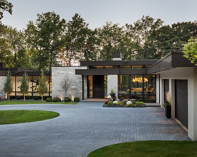 modern stone home exterior front entry and circle driveway