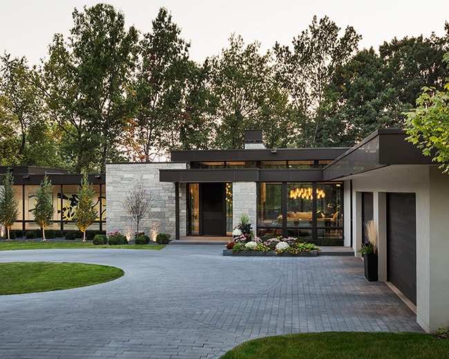 modern stone home exterior front entry and circle driveway